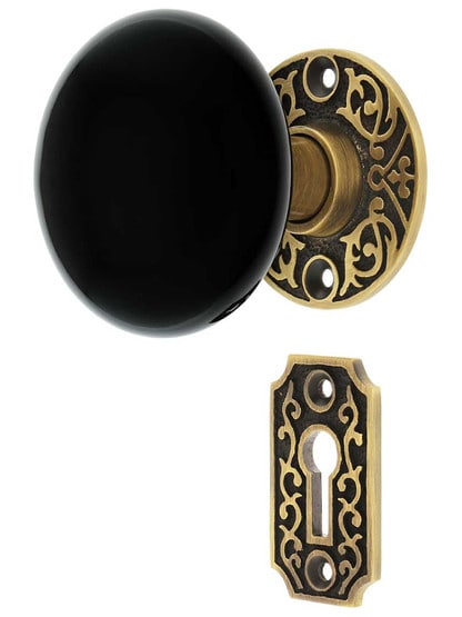 Scroll Rosette Mortise Lock Set with Black Porcelain Door Knobs in Antique Brass.